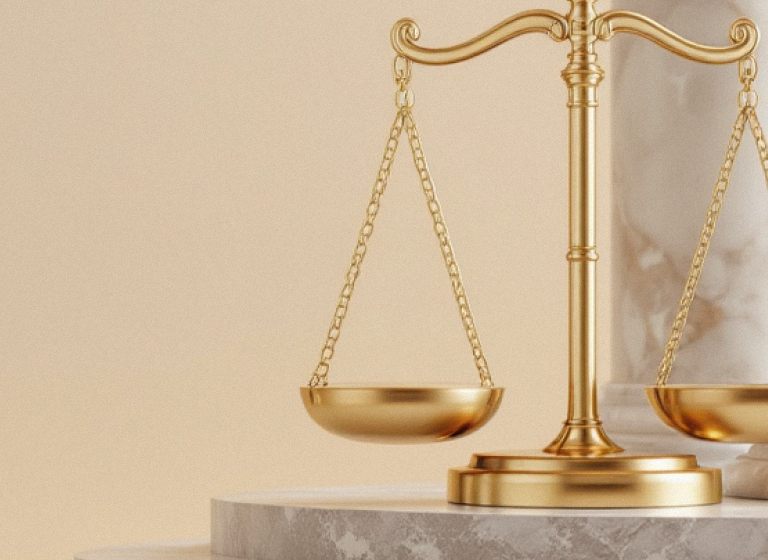Golden scale balanced and resting atop a marble pedestal against a beige background with a marble pillar